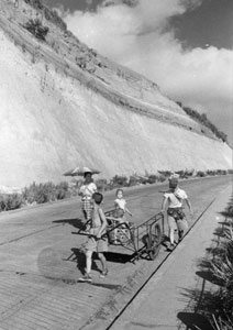 稲荷坂の親子　昭和29年（1954）８月14日　南区山谷の高台から中村橋へとくだる急坂。左手は、明治初年、堀割川の開削で出来た切り通しの崖。