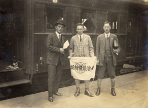 写真６　横浜貿易新報の旗を前にする岡本三朗（左）　昭和初期（岡本すみ子氏所蔵）